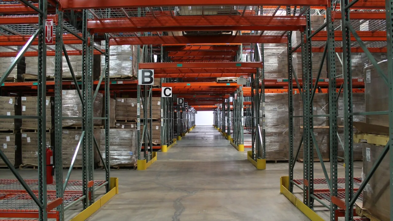 Interior de un almacén con mercancía, estanterías y pasillos de trabajo