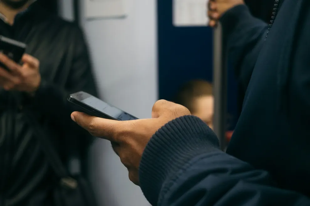 Persona usa un teléfono Android en un entorno de transporte público